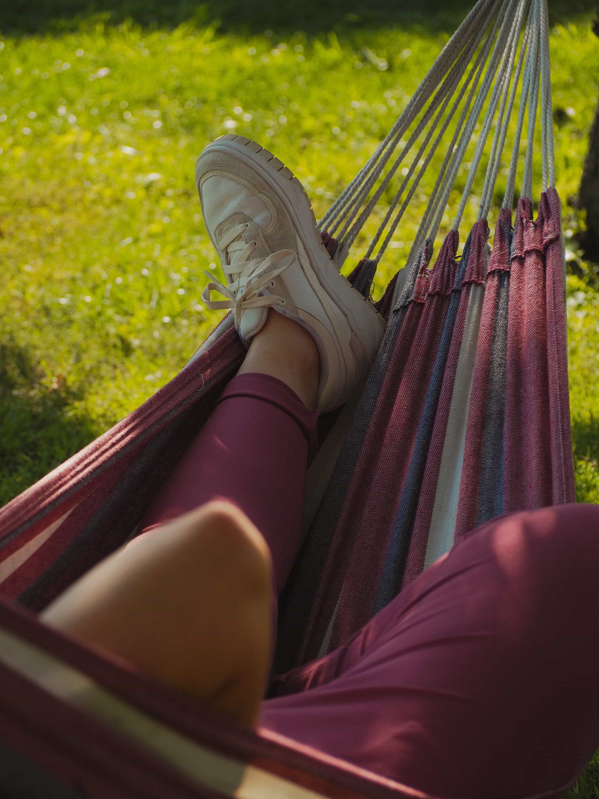 Top-down view of a person resting in a hammock with their legs elevated to manage symptoms of dysautonomia, a condition that is notoriously hard to diagnose.