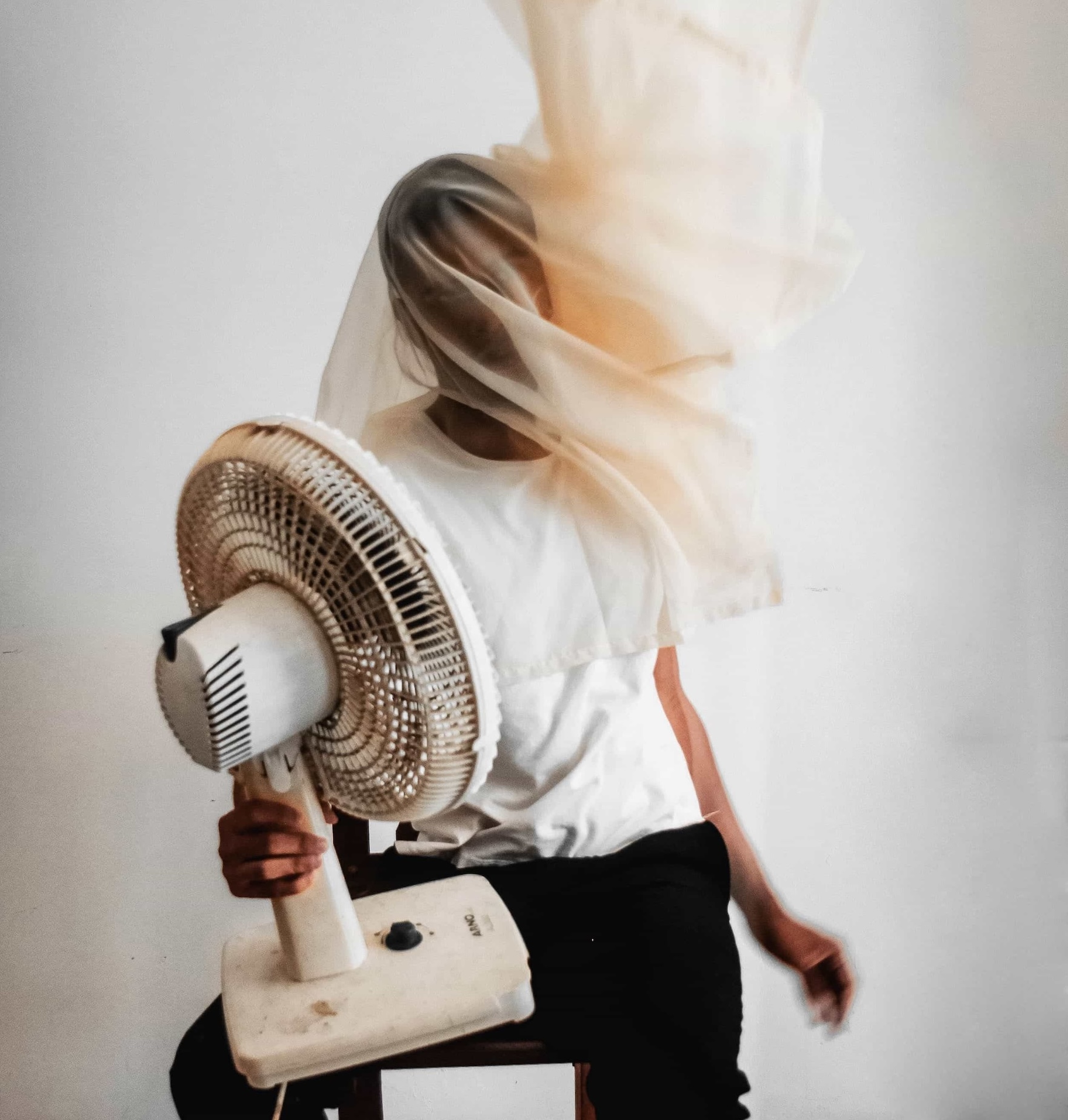 Woman using a fan for perimenopause and menopause hot flash relief